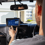 Driver using the Universal CarPlay Dashboard to control music and navigation on a touchscreen display inside a car